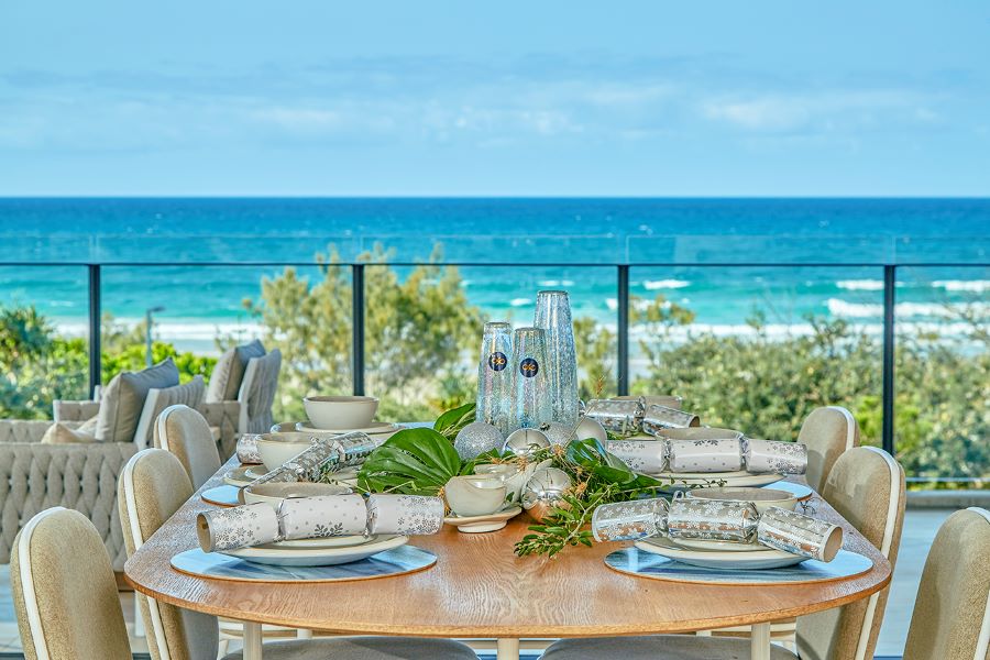 Prize Home Draw 482's outdoor dining set-up with views of the ocean in the background
