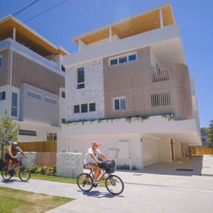 People riding bikes past the outside of our Miami Prize Home