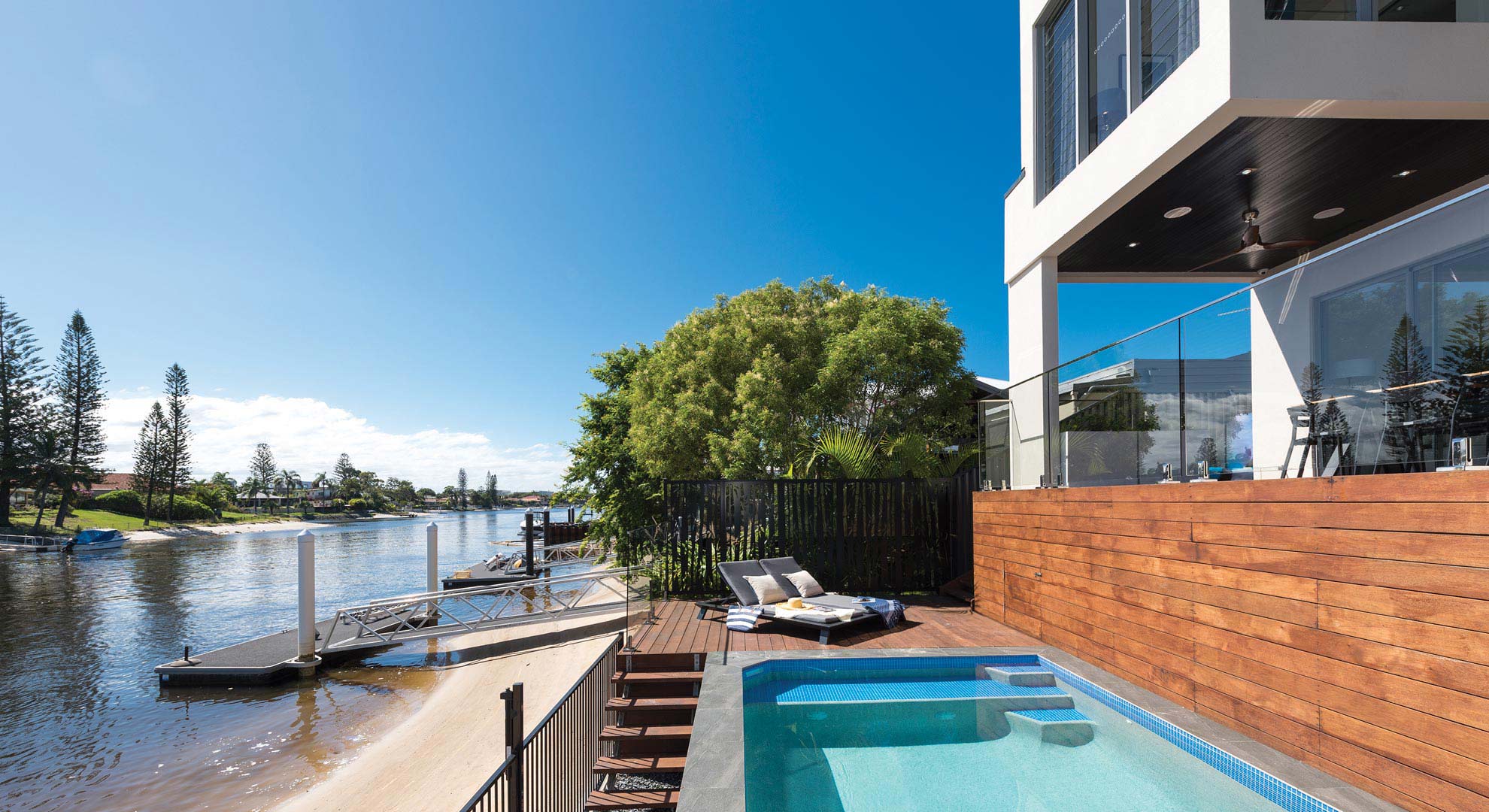 photo of a house with a pool next to a river